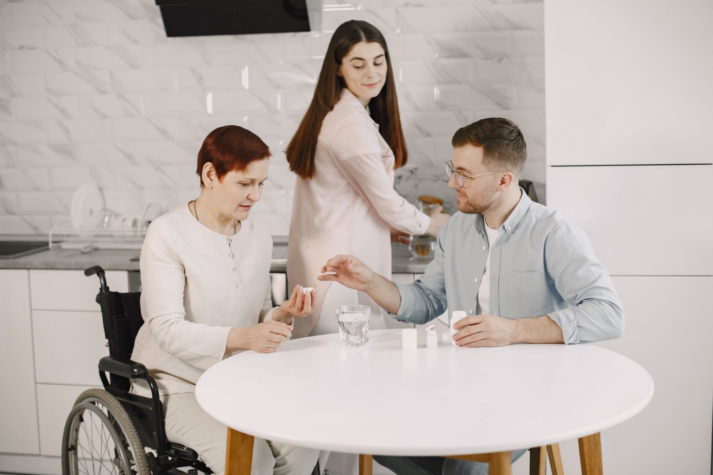 Family and support worker helping an NDIS participant with daily medication at home